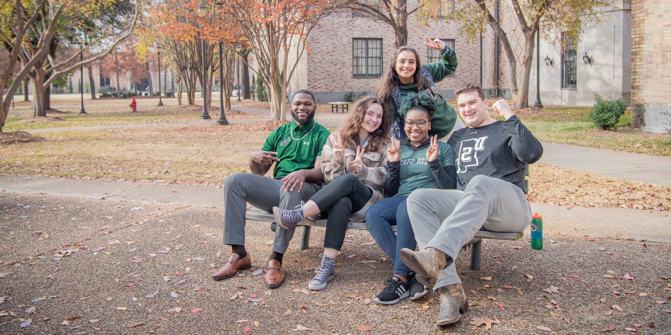 转移 students hanging out on campus in Delta State gear.